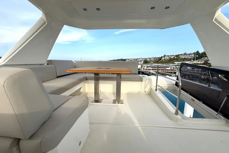 Freiheit Yacht Photos Pics Luxurious 2020 Prestige 590 yacht interior with seating and table, overlooking marina.