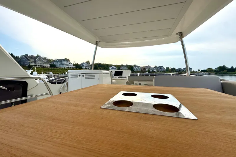 Freiheit Yacht Photos Pics Prestige 590 yacht deck with table, overlooking waterfront homes, 2020 model.