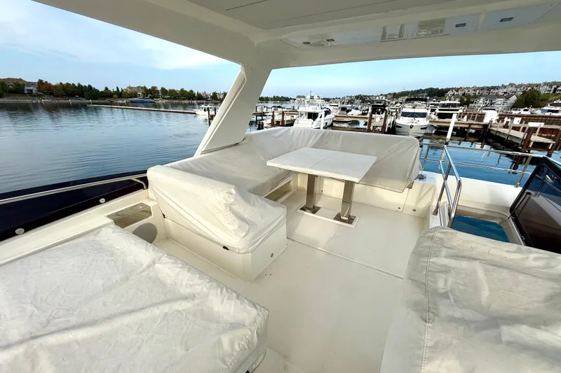 Freiheit Yacht Photos Pics Prestige 590 yacht 2020 model, featuring spacious deck with seating and table, docked at marina.