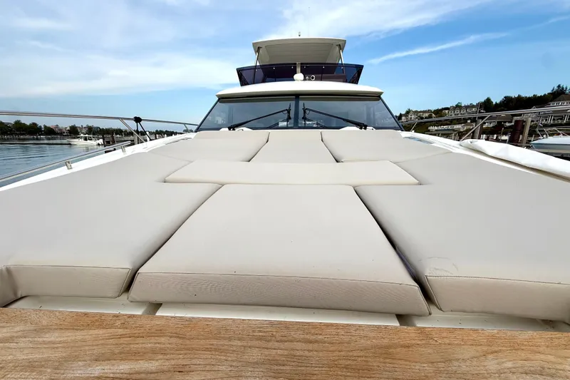 Freiheit Yacht Photos Pics Prestige 590 yacht 2020 model with spacious sunbathing deck, docked by serene waters.
