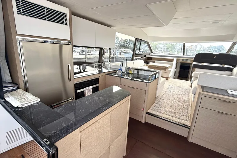 Freiheit Yacht Photos Pics Luxurious interior of 2020 Prestige 590 yacht with modern kitchen and spacious seating area.
