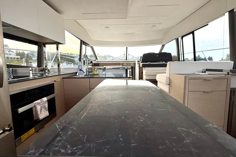 Freiheit Yacht Photos Pics Luxurious interior of a 2020 Prestige 590 yacht with modern kitchen and seating area.