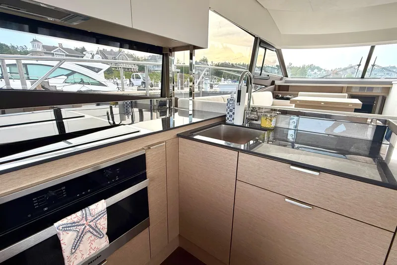 Freiheit Yacht Photos Pics Modern kitchen interior on 2020 Prestige 590 yacht, featuring sleek countertops and appliances.