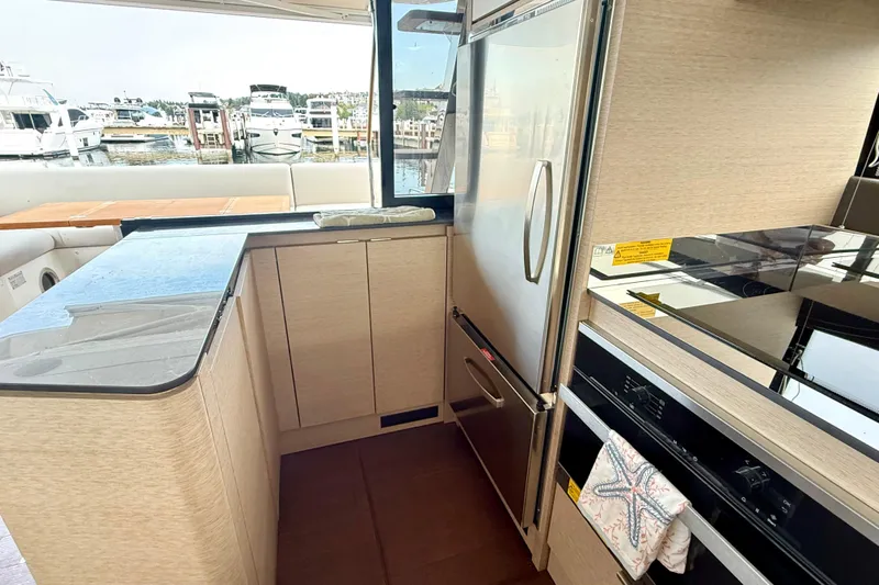 Freiheit Yacht Photos Pics Modern kitchen interior on a 2020 Prestige 590 yacht, featuring sleek appliances and waterfront view.