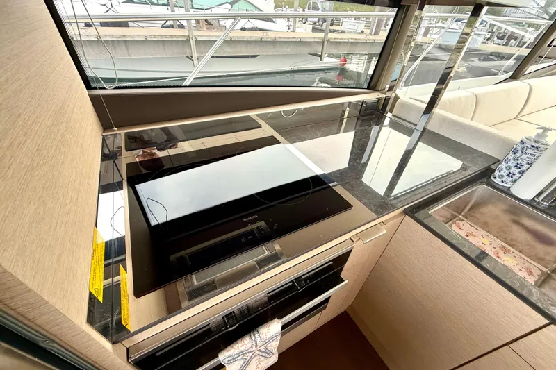 Freiheit Yacht Photos Pics Modern kitchen area in a 2020 Prestige 590 yacht with sleek appliances and sink.