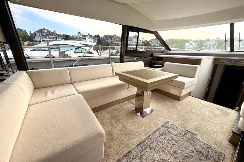 Freiheit Yacht Photos Pics Luxurious interior of 2020 Prestige 590 yacht with beige seating and modern table.