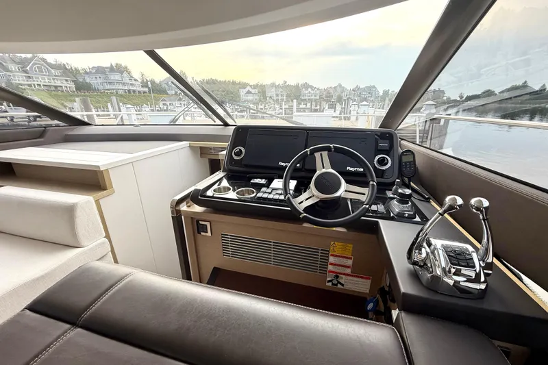 Freiheit Yacht Photos Pics Interior view of 2020 Prestige 590 yacht helm with modern controls and scenic marina backdrop.