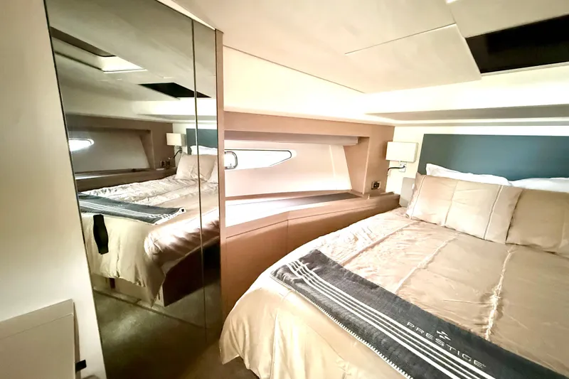 Freiheit Yacht Photos Pics Luxurious bedroom interior of 2020 Prestige 590 yacht with elegant bedding and mirrored closet.