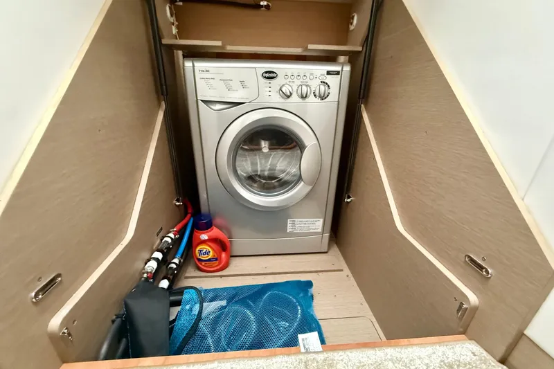 Freiheit Yacht Photos Pics Laundry area on a 2020 Prestige 590 yacht with washing machine and detergent.