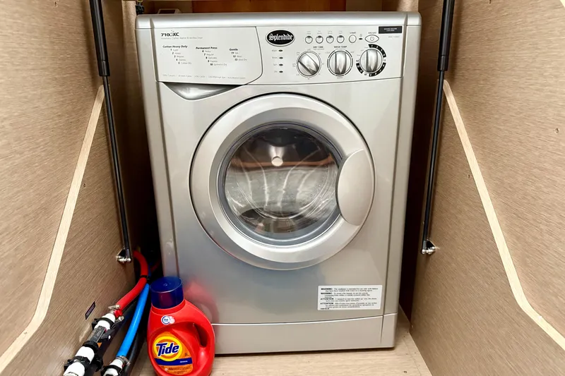 Freiheit Yacht Photos Pics Front-loading washing machine in a compact space with Tide detergent bottle nearby.
