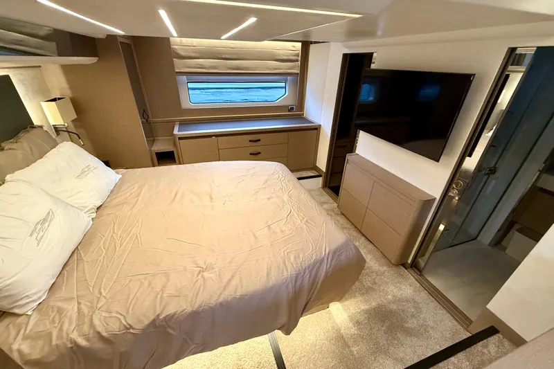 Freiheit Yacht Photos Pics Luxurious bedroom interior of 2020 Prestige 590 yacht with modern furnishings and large window.