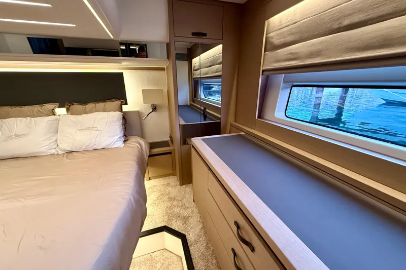 Freiheit Yacht Photos Pics Luxurious bedroom interior of 2020 Prestige 590 yacht with elegant furnishings and window view.