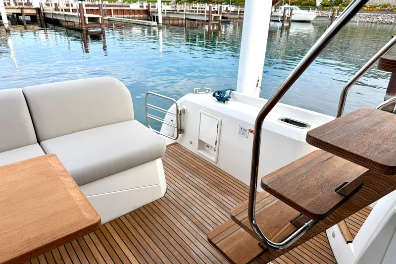 Freiheit Yacht Photos Pics Prestige 590 yacht deck, 2020 model, featuring wooden flooring and comfortable seating.