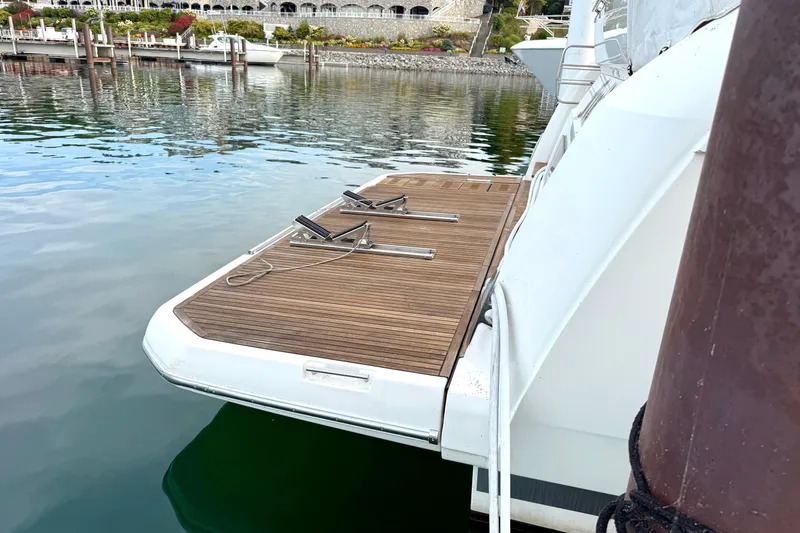 Freiheit Yacht Photos Pics Luxury yacht Prestige 590, 2020 model, docked with wooden swim platform.