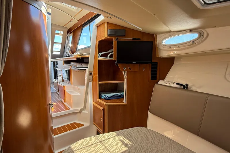 Frisky Yacht Photos Pics 2022 Cutwater C-32 CB interior with wood finishes, TV, and seating area.