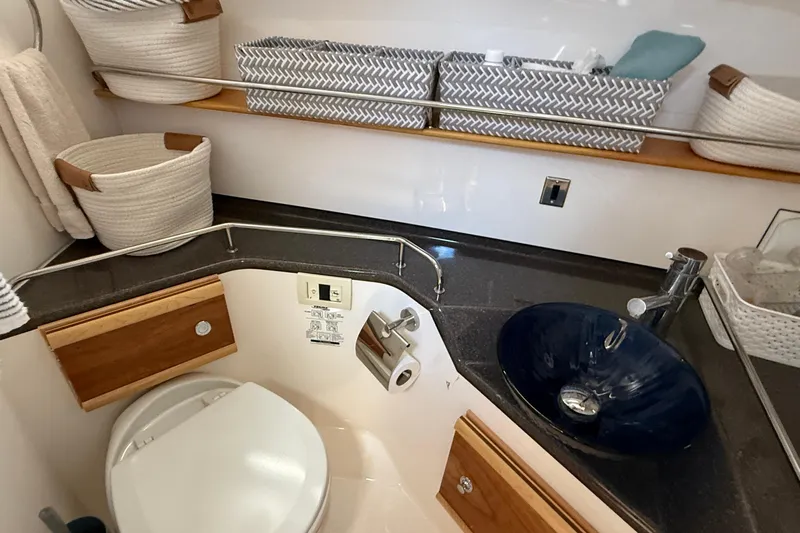 Frisky Yacht Photos Pics 2022 Cutwater C-32 CB bathroom with modern sink, toilet, and storage baskets.