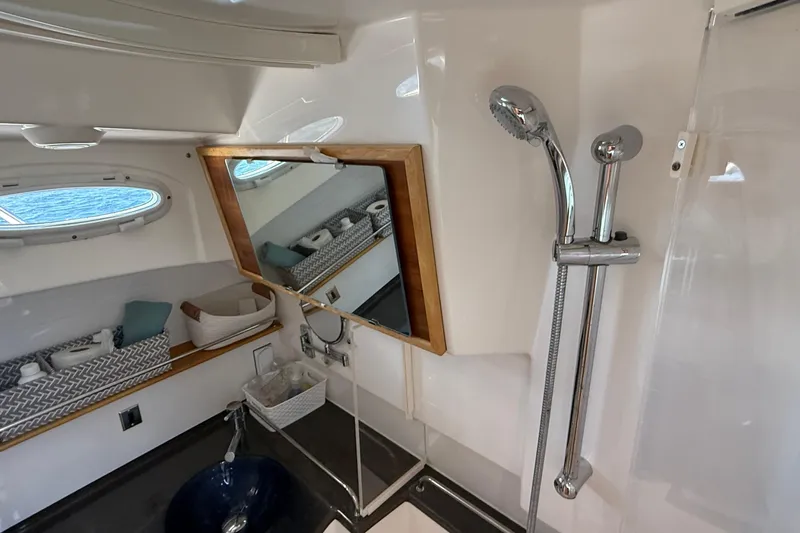 Frisky Yacht Photos Pics 2022 Cutwater C-32 CB bathroom with shower, mirror, and storage shelves.