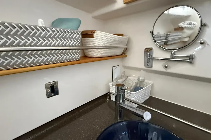 Frisky Yacht Photos Pics 2022 Cutwater C-32 CB bathroom with sink, mirror, and storage baskets.