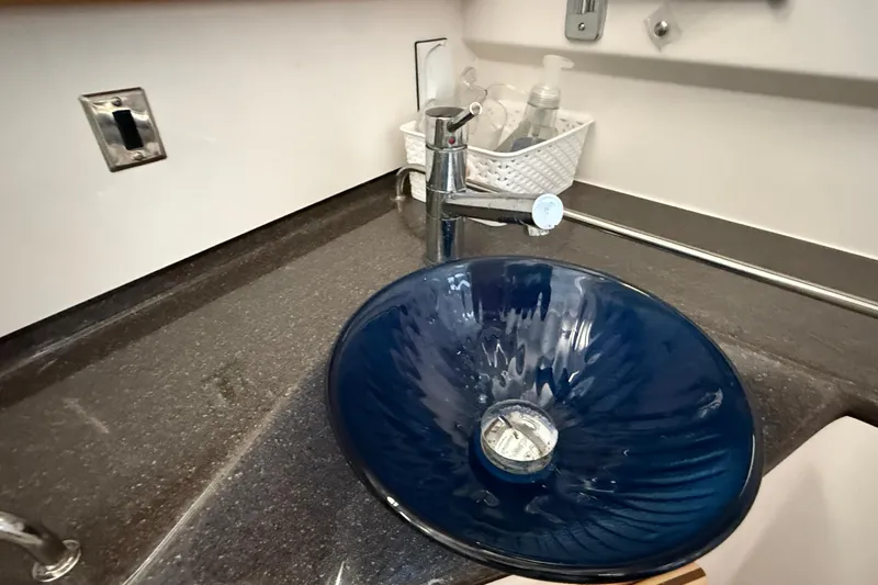 Frisky Yacht Photos Pics Blue glass sink in 2022 Cutwater C-32 CB boat bathroom, with modern faucet and countertop.