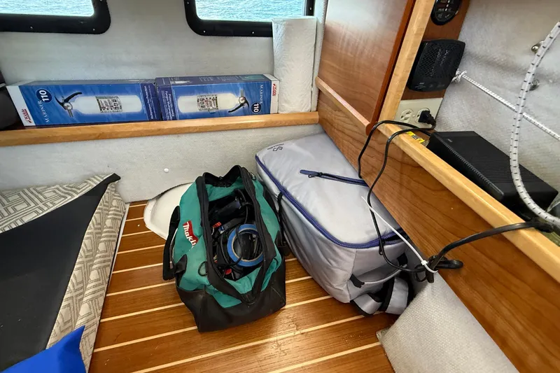 Frisky Yacht Photos Pics Interior of 2022 Cutwater C-32 CB with gear bags and equipment on wooden floor.