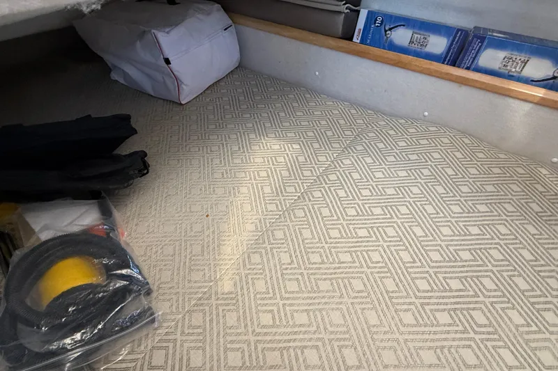 Frisky Yacht Photos Pics Interior storage area of 2022 Cutwater C-32 CB boat with patterned flooring and equipment.