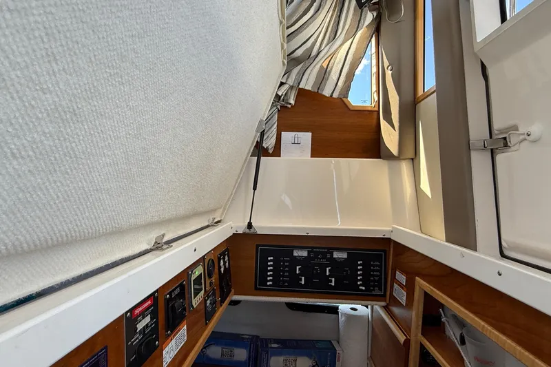 Frisky Yacht Photos Pics 2022 Cutwater C-32 CB cabin interior with control panel and striped curtains.