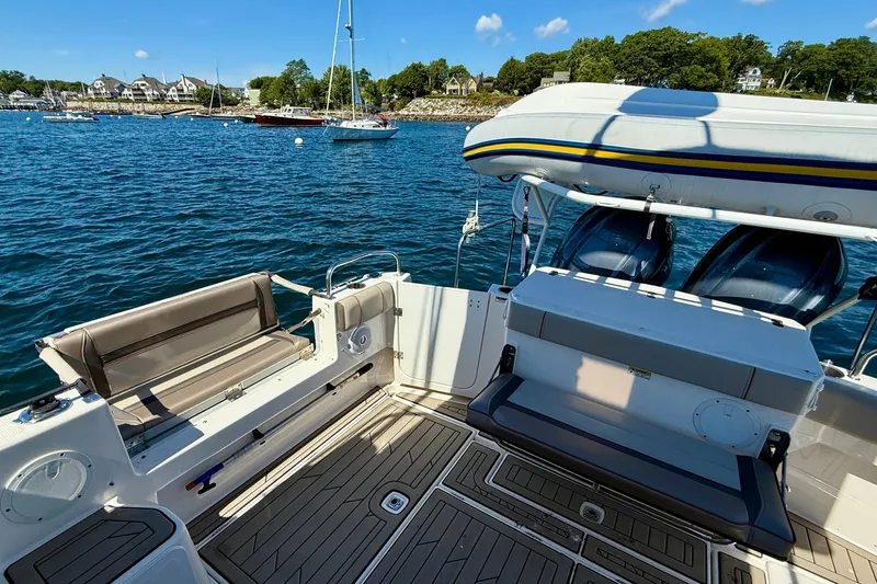 Frisky Yacht Photos Pics 2022 Cutwater C-32 CB boat deck with seating, docked near scenic shoreline.