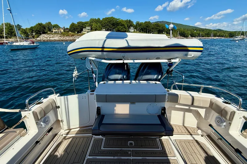 Frisky Yacht Photos Pics 2022 Cutwater C-32 CB boat deck with seating, inflatable boat, and scenic waterfront view.