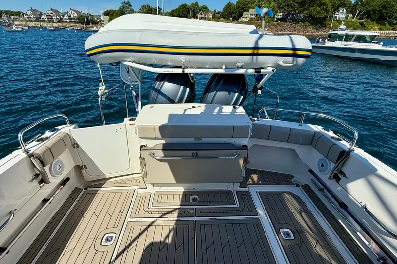 Frisky Yacht Photos Pics 2022 Cutwater C-32 CB boat deck with inflatable dinghy, docked in a scenic harbor.