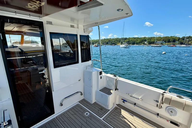 Frisky Yacht Photos Pics 2022 Cutwater C-32 CB boat interior with scenic harbor view and moored sailboats.