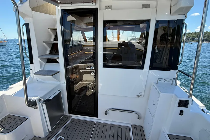 Frisky Yacht Photos Pics 2022 Cutwater C-32 CB boat interior with stairs, glass door, and scenic water view.