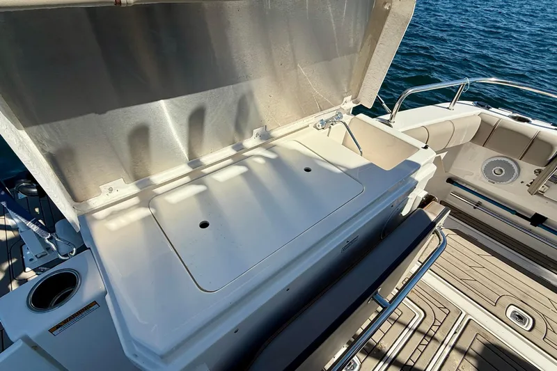 Frisky Yacht Photos Pics 2022 Cutwater C-32 CB boat deck with open storage compartment and seating area.