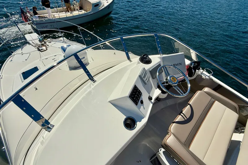 Frisky Yacht Photos Pics 2022 Cutwater C-32 CB boat helm with steering wheel and seating on open water.