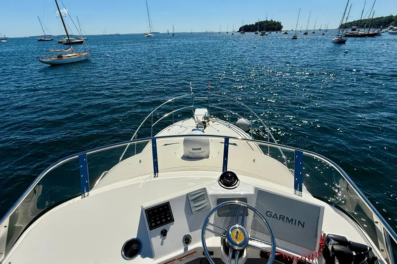 Frisky Yacht Photos Pics 2022 Cutwater C-32 CB boat navigating scenic waters with sailboats and islands in view.