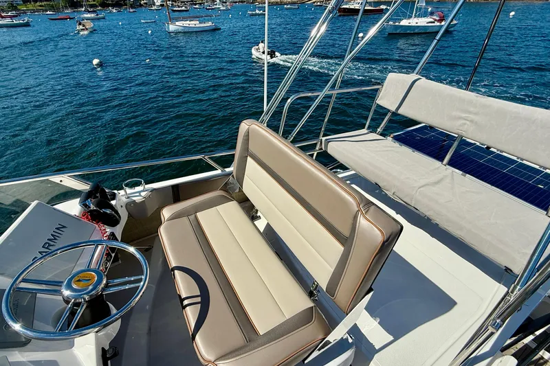 Frisky Yacht Photos Pics 2022 Cutwater C-32 CB boat interior with steering wheel and seating, docked in a marina.
