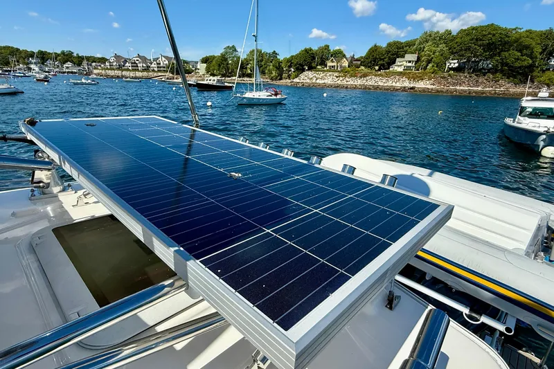 Frisky Yacht Photos Pics 2022 Cutwater C-32 CB boat with solar panels on deck, docked in a scenic harbor.