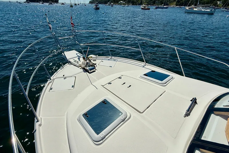 Frisky Yacht Photos Pics 2022 Cutwater C-32 CB boat deck with hatches, anchored in a scenic harbor.