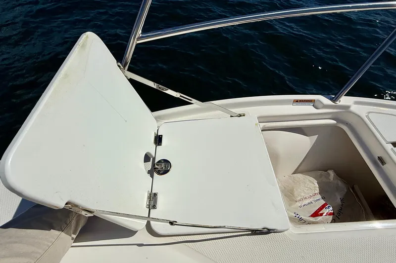 Frisky Yacht Photos Pics Open storage compartment on 2022 Cutwater C-32 CB boat, with ocean in background.