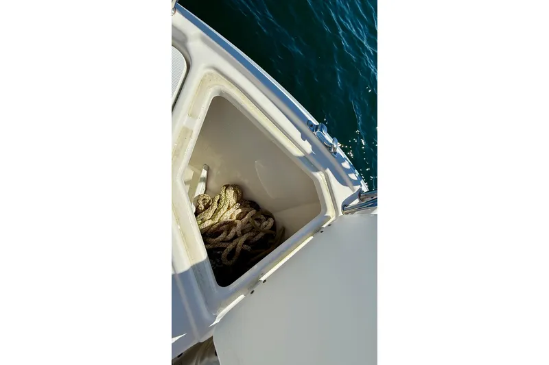 Frisky Yacht Photos Pics Storage compartment with rope on 2022 Cutwater C-32 CB boat, near water.