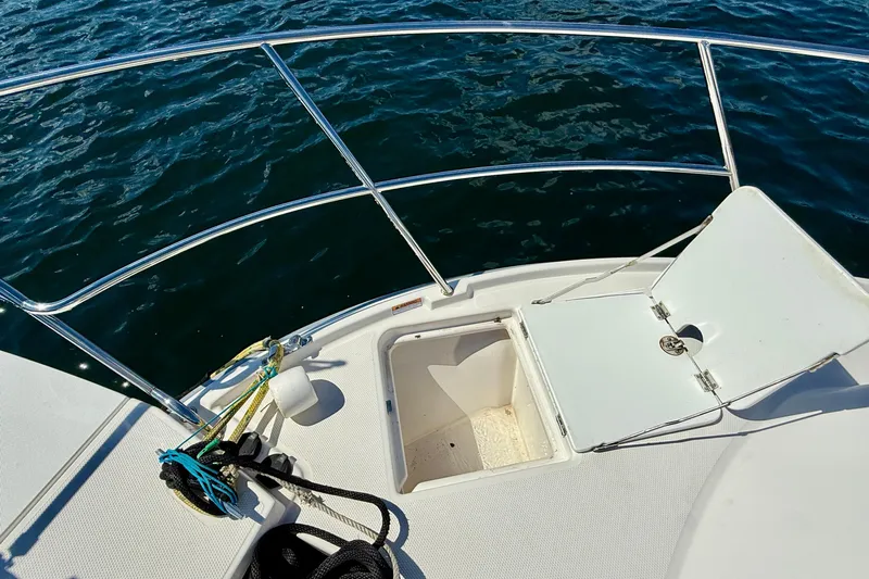 Frisky Yacht Photos Pics 2022 Cutwater C-32 CB boat deck with open hatch and railing, overlooking water.