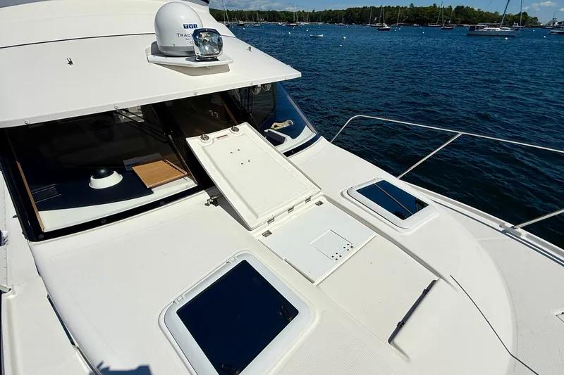 Frisky Yacht Photos Pics 2022 Cutwater C-32 CB yacht deck with open hatch, docked on serene water.