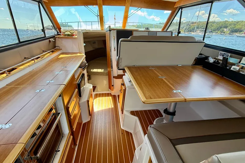 Frisky Yacht Photos Pics Interior of 2022 Cutwater C-32 CB boat with wood finishes and scenic window views.