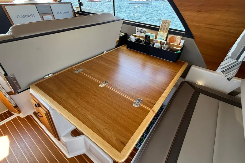 Frisky Yacht Photos Pics Interior of 2022 Cutwater C-32 CB boat with wooden table and seating area.