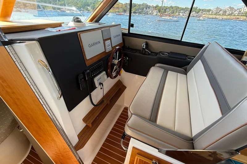 Frisky Yacht Photos Pics 2022 Cutwater C-32 CB helm with Garmin navigation, luxurious seating, and scenic water view.