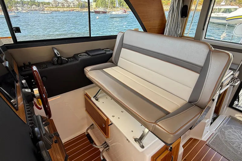 Frisky Yacht Photos Pics 2022 Cutwater C-32 CB interior with cushioned seating and scenic water view.