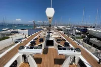 Deck view of 2006 Custom Felci 71 yacht in marina, showcasing controls and wood finish.