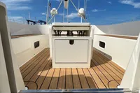 Custom Felci 71 yacht deck, 2006 model, featuring sleek design and wooden flooring under a clear sky.