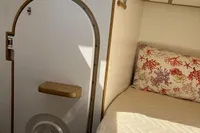 Interior of 2006 Custom Felci 71 yacht with cozy bed and nautical-themed decor.