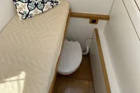 Small cabin interior of 2006 Custom Felci 71 yacht with bed and decorative pillow.