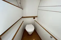 Compact bathroom on a 2006 Custom Felci 71 yacht, featuring modern white and wood design.